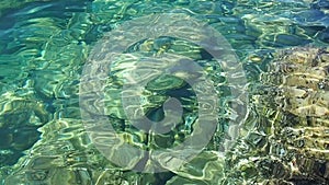 Green azure turquoise blue transparent sea salt water texture. Slow motion. Water surface and ripples. Water sea waves