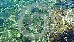 Green azure turquoise blue transparent sea salt water texture. Slow motion. Water surface and ripples. Water sea waves