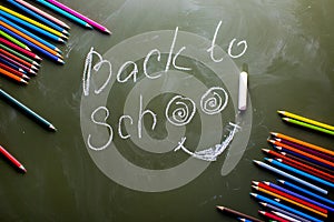 Green backboard label Back to school and a set of colored pencil