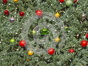 On a green background of an artificial Christmas tree multi-colored balls and garlands.