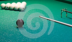 On a green background of a billiard table, white balls are lined with a triangle with a cue for playing