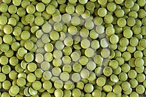 Green background made of barley grass tablets, top view