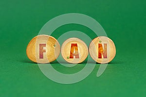 On a green background, wooden roundels with the inscription - FAN
