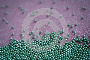 Green ball crystal sugar sprinkle dots, on glitter pink background.