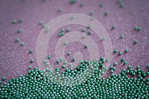 Green ball crystal sugar sprinkle dots, on glitter pink background.