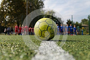 Green ball on a green football field. Street football. Summer photo of the minifootball.