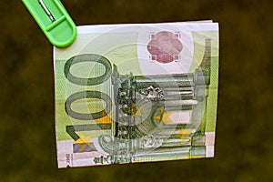 Green banknote 100 euro in green clothes peg