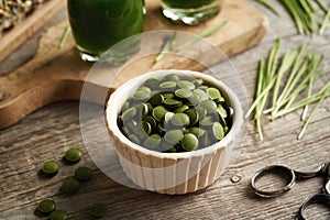 Green barley grass tablets with fresh blades and homemade juice