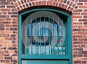 Green barred up window in the distillery district, Toronto, Ontario