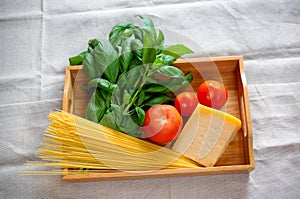 Green basil, chunk of parmesan cheese, raw cappellini and tomatoes