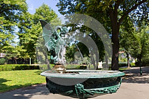 Green Basilisk Fountain spouting water in basin at Stadtpark, City Park in Vienna, Austria