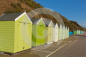 Green beach huts in a row with blue sky