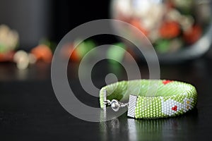 Green beaded bracelet with white cat and red hearts