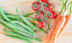 Green beans, Cherry tomatoes, baby Carrots on wooden background