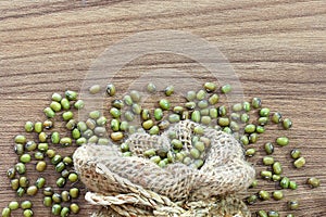 Green beans in sack, on wooden texture background with free space