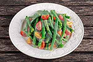 Green beans salad with Red, Yellow Tomatoes on white plate