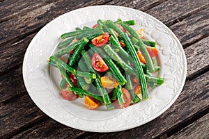 Green beans salad with Red, Yellow Tomatoes on white plate