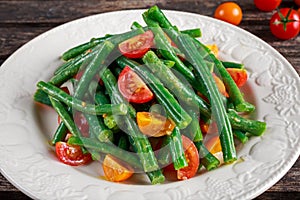 Green beans salad with Red, Yellow Tomatoes on white plate