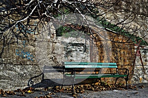 Green bench by the wall whit wall graffiti as background