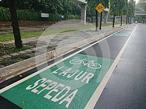 Green bicycle track and road sign in indonesia language, jalur sepeda