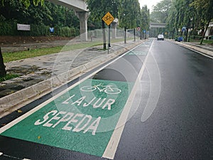 Green bicycle track and road sign in indonesia language, jalur sepeda