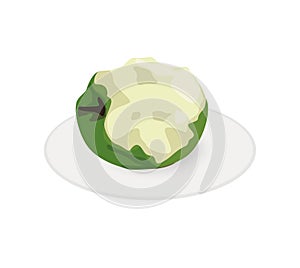 Green bitten apple on a plate