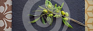 Green and black olives with leaves on dark background. Copy space, flat lay BANNER, LONG FORMAT
