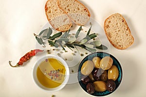 Green and black olives in porcelain bowl with olive oil with fr