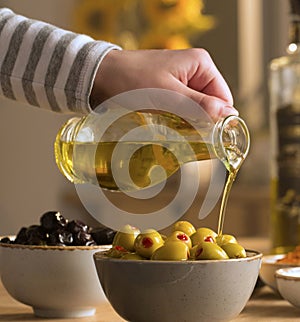 Green and black olives in their bowls with fresh olive oil pouring over them