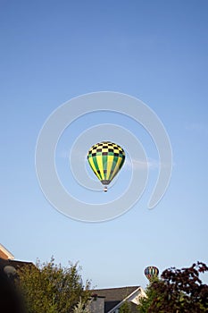 Green, Black, and Yellow Hot Air Balloons flying overhead at Ashland Balloonfest