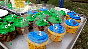 Green and blue cupcakes with tongues on tray