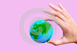 Green and Blue Globe in Hand on Pink