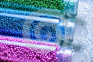 Green, blue and pink beads for nail design close-up