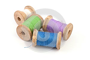 Green blue purple white sewing thread on white background 