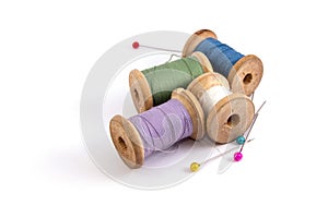 green blue purple white sewing threads and colored needles on white background isolated