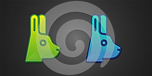 Green and blue Rabbit with ears icon isolated on black background. Magic trick. Mystery entertainment concept. Vector