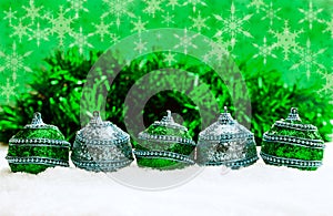 Green and blue and silver Christmas balls in snow with tinsel and snowflakes, christmas background