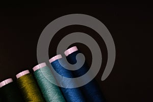 green and blue threads with black background