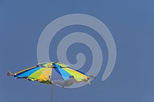 Green, Blue and Yellow Beach Umbrella Against Blue Sky