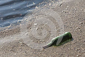 Green bottle in a pond, pollution and littering.