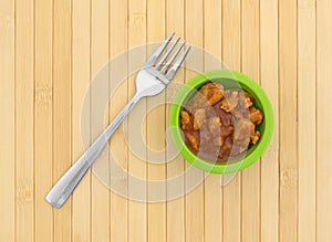 Green bowl with chicken chunks in barbecue sauce