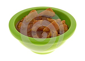 Green bowl with chicken chunks in barbecue sauce