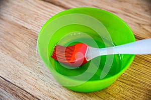 Green bowl with oil and red pastry brush