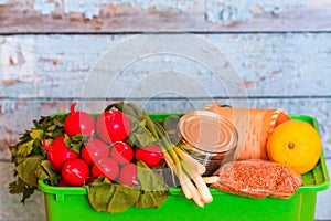 Green box with food on a blue background, fresh organic vegetables, garden products at the farmers market