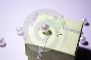 Green box with a pearl. Bead on the box. Plastic bead. Placer beads. White beads. photo