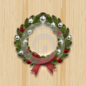 A green branch ate in the shape of a Christmas wreath with a shadow. Silver and red balls, red bow on the background of