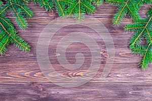 Green branches of a Christmas tree on a dark wooden background. Place for an inscription. The basis for the postcard