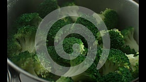 Green broccoli is cooked in steam in a stainless steel steamer.Slow motion. Very beautiful studio shot. Slow motion. Camera Phanto