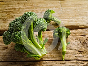Green broccoli on a simple wooden table. Close-up. Minimalism. Organic food, healthy lifestyle. There are no people in the photo.