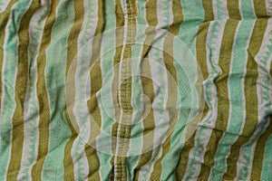 Green brown fabric texture from a piece of crumpled clothes